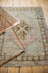 Hand-knotted distressed Oushak rug with stepped medallion, dusty rose, ivory, and bronze tones.