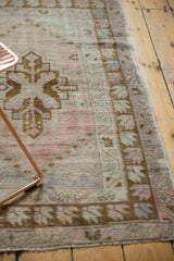 Distressed vintage Oushak rug pile shows faint foundation and geometric pale bronze border.