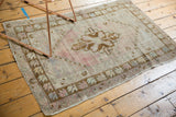 Faded rose and bronze floral border detail on a distressed vintage Turkish Oushak rug.
