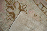 Distressed Oushak rug detail: hand-knotted foundation, worn pile in dusty rose and pale bronze.
