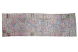Distressed Oushak runner, repeating floral medallions in soft pink, blue, and terra cotta.