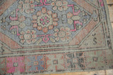 Distressed Oushak runner border detail showing pale blue, terra cotta, and pink motifs.
