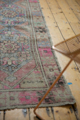 Distressed Oushak runner's secured end, highlighting even wear and faded pink, blue colors.