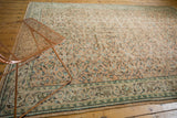 Distressed Oushak rug with pale apricot peach and mint scrolling vinery.