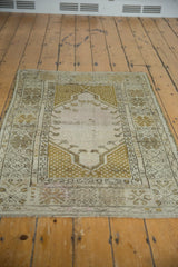 Angled close-up of even wear, faint foundation, and germinating floral motifs on a vintage Melas rug.