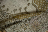 Distressed Melas rug texture, showing even wear and faint foundation through beige and bronze patterns.