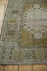 Distressed Melas rug border with intricate seed motifs and softly worn pile.