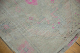 Close-up of distressed vintage Oushak rug, revealing even low pile and faded pink accents.