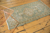 Vintage distressed Oushak rug corner with scalloped medallion, seafoam green, and mostly even wear.