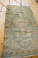 Distressed fringe, muted seafoam green and beige border of a vintage Turkish Oushak rug, with mostly even wear.