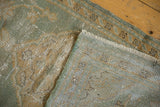 Distressed seafoam green pile and hand-knotted foundation of the vintage Oushak rug.