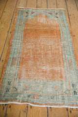 Distressed tangerine orange field and seafoam green border of a vintage Oushak rug runner.