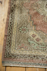 Vintage Oushak rug's distressed texture, showing even wear to knot heads, dusty rose and mint green.