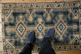 Distressed Northwest Persian rug corner with indigo blue, beige patterns, showing even wear to knot heads.