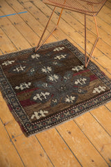 Distressed Oushak rug corner showing low worn pile, chocolate brown, oxidized silver, and ivory medallion.