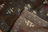 Distressed low pile and ivory motifs on a chocolate brown Oushak rug's folded edge.