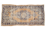 Vintage Distressed Oushak runner with pale dusty gold field, cobalt blue medallion, and aged texture.