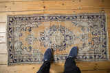Distressed Oushak rug runner, pale gold and cobalt blue, with foundation showing through.