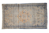 Distressed vintage Oushak rug runner with faded ivory, dusty gold, and denim blue medallion.