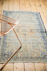 Distressed vintage Oushak runner pile, showing even wear and softened denim blue and dusty gold motifs.