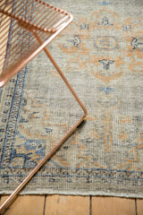 Distressed pile texture of vintage Oushak rug with faded blue and gold motif.