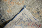 Distressed Oushak runner's hand-knotted pile texture, with denim blue, dusty gold, ivory tones, cobalt selvedge, and woven reverse.