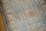 Oushak runner's secured side edge, distressed texture, and faded patterns.