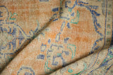 Distressed Oushak rug pile, showing even wear to knot heads, faded saffron, ivory, blue, mint.