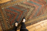 Antique Kurdish rug featuring intersecting floral stripes and a wide, plain camel border.