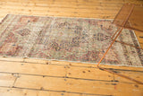 Antique Kerman runner: scalloped floral medallions in cochineal red, navy, and ivory. Visible wear.