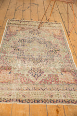 Traditional Persian Kerman rug detail, ivory, red, navy floral pattern with visible pile wear.
