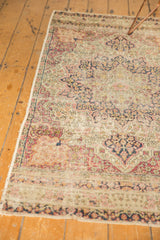 Antique Kerman rug runner showing worn floral pattern in ivory, cochineal red, navy.