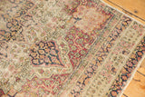 Antique Kerman rug runner fragment with pile wear revealing foundation, machine-bound edge.