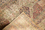 Worn floral pattern, visible knot heads, and machine-bound edge of an Antique Kerman rug.