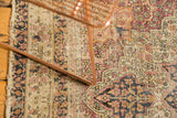 Antique Kerman rug detail, revealing worn ivory, red, navy floral blossoms and exposed foundation.