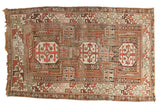 Antique Caucasian hand-knotted rug, geometric triple medallions in copper, rust, charcoal, ivory.