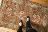 Antique Caucasian rug with a detailed geometric rams horn medallion, rectilinear patterns, and rust, copper, ivory tones.