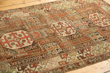 Antique Caucasian rug detail showcasing copper, ivory, and dark wine geometric rams horn patterns.