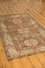Rectilinear infinity knots and geometric arabesque border with time-softened tones on the antique Caucasian rug.