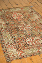Antique Caucasian rug's classic geometric arabesque border and rectilinear field motifs. Copper, rust, ivory hues.