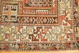 Antique Caucasian rug's geometric border in rust, brown, and ivory, showing worn selvedge.