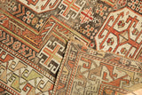 Folded antique Caucasian rug corner displays geometric patterns, aged pile, and hand-knotted foundation.