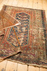 Stepped floral field, boteh vine border, rust, navy, with wear on vintage Hamadan rug.