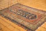 Hamadan rug's classic serbend border, boteh motifs in rust, navy, and tattered ends.