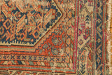 Worn edge detail of vintage Hamadan rug, with exposed foundation and tattered fringe.
