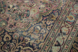 Faded plum and navy floral vinery texture on a worn vintage Meshed rug.