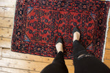 Vintage Persian Engelas rug, cherry red Herati field with textured pile, navy border.