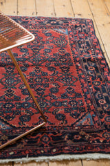Cherry red Herati motif field and navy blue samovar-turtle border on a vintage Engelas rug.