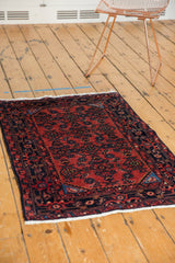 Vintage Engelas rug corner: cherry red field, blossomed wool, navy border, white fringe.