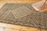 Antique Senneh rug's detailed diamond medallion and Herati motif, navy, ivory, and blush tones.